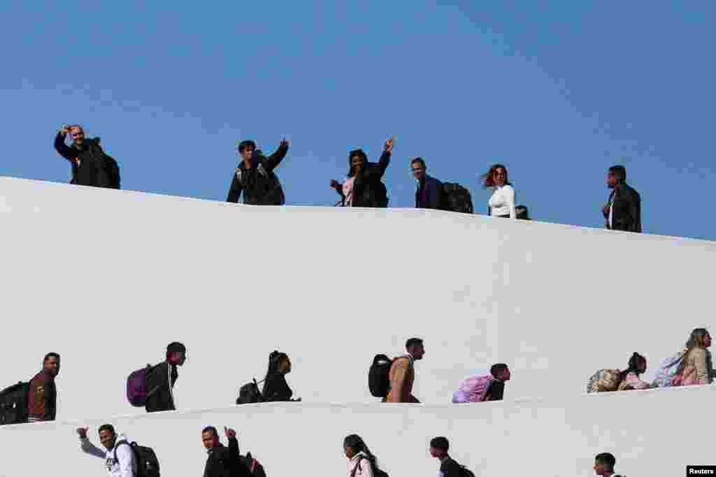 Migrants who requested an appointment for asylum in the United States walk towards El Chaparral, at the border between Mexico and the U.S, in Tijuana, Mexico Nov. 4, 2024. 