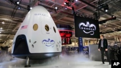 FILE - Elon Musk, right, unveils the SpaceX Dragon V2 spacecraft Thursday, May 29, 2014, in Hawthorne, CA. (AP Photo/Jae C. Hong)