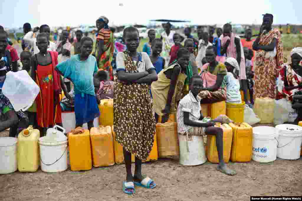 Children queue for water in the UNMISS camp near Bentiu. As of the end of June, about 81,000 internally displaced persons, including at least 28,000 new arrivals in April and May, lived in the camp in cramped and unsanitary conditions.