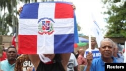 Une femme brandit un drapeau dominicain lors d'une marche pour protester contre la suspension des élections municipales nationale, à Saint-Domingue, en République dominicaine, le 23 février 2020. REUTERS/Ricardo Rojas