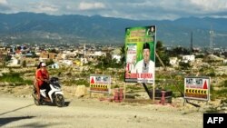 Dua orang warga yang mengendarai sepeda motor melewati baliho pemilu bergambar seorang Caleg di Palu, Sulawesi Tengah (foto: ilustrasi). 