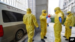 湖北省的丧葬人员在处理了一名感染病毒的患者遗体后进行消毒。(2020年1月30日)