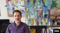 집안 작업실에서 자신의 작품을 배경으로 포즈를 위한 루크만 아흐마드.