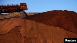 FILE - Mining company Rio Tinto, shown unloading iron ore in Australia in December 2013, in 2020 destroyed two sacred rock shelters in Australia dating back 46,000 years.