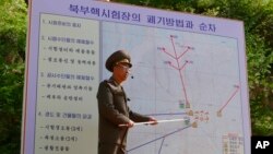 지난 5월 북한 풍계리 핵실험장 폭파 폐기에 앞서 당국자가 갱도와 관련 시설의 폐기 방법과 순서를 외국 기자들에게 설명하고 있다.