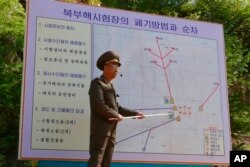 지난 24일 북한 풍계리 핵실험장에서 북한 당국자가 갱도와 관련 시설의 폐기 방법과 순서를 설명하고 있다.