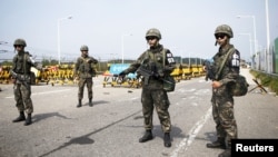 Tentara Korea Selatan berjaga-jagai di pos pemeriksaan Jembatan Unifikasi yang menuju ke desa gencatan senjata Panmunjom, sebelah selatan zona demiliterisasi yang memisahkan kedua Korea tersebut, di Paju, Korea Selatan, 24 Agustus 2015.