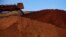FILE - Mining company Rio Tinto, shown unloading iron ore in Australia in December 2013, in 2020 destroyed two sacred rock shelters in Australia dating back 46,000 years.