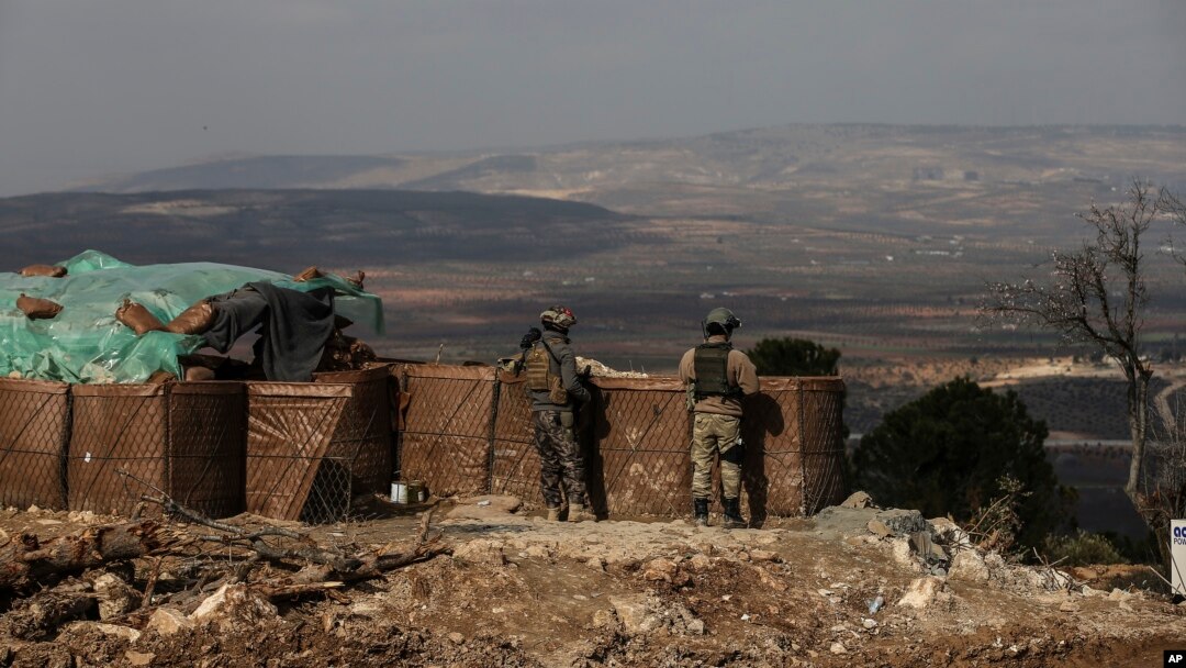 Dua tentara Turki memantau situasi di Afrin, Suriah dari bukit Bursayah (3/3). 