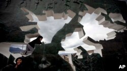 FILE - A child climbs on the Malvinas Island war memorial during a ceremony marking the 30th anniversary of the conflict between Argentina and Great Britain over the remote South Atlantic archipelago, in Ushuaia, Argentina, Monday April 2, 2012. 