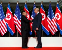 FILE - Kim Jong Un and President Donald Trump shake hands prior to their meeting in Singapore, June 12, 2018.