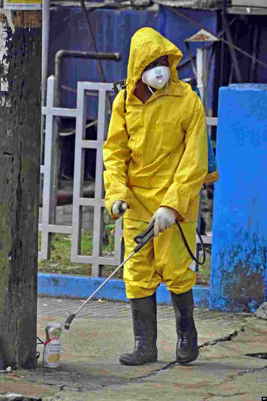 An employee of the Monrovia City Corporation sprays disinfectant along the streets to prevent the spread of the deadly Ebola virus, Monrovia, Liberia, August 1, 2014.