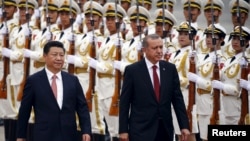 Turkey's President Recep Tayyip Erdogan, right, and his Chinese President Xi Jinping inspect honor guards during a welcoming ceremony outside the Great Hall of the People in Beijing, July 29, 2015.