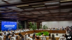 Delegaciones del gobierno colombiano y del grupo guerrillero Ejército de Liberación Nacional (ELN) de Colombia asisten a la ceremonia de apertura del tercer ciclo de conversaciones de paz en La Habana, Cuba, el martes 2 de mayo de 2023. (Foto AP/Ramon Espinosa).