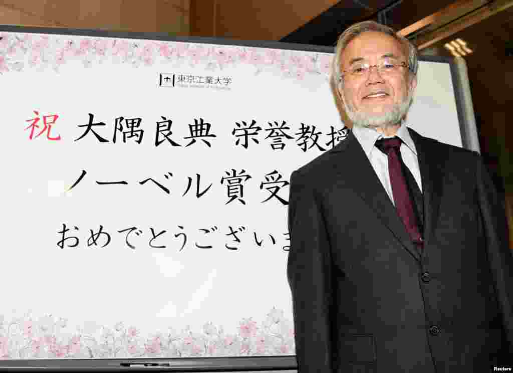 Yoshinori Ohsumi, a professor of Tokyo Institute of Technology smiles in front of a celebration message board after he won the Nobel medicine prize in Yokohama, Japan, Oct. 3, 2016 in this photo released by Kyodo.