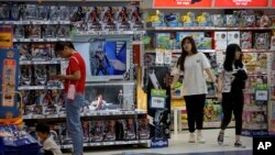 Clientes compran cerca de un puesto con figuras de la saga de Marvel Avengers, fabricadas por la empresa estadounidense Hasbro, en una tienda de juguetes en Beijing, el 23 de mayo de 2019. 