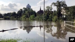 The Missouri Capitol, which is wrapped in plastic while under renovation, is reflected in floodwaters that submerged a parking lot for state employees in Jefferson City, Mo., on May 29, 2019. 