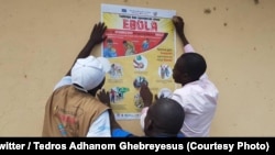 Une équipe de l'OMS colle une affiche de sensibilisation à l'épidémie d'Ebola, Beni, Nord-Kivu, RDC, le 15 octobre 2018. (Twitter/Tedros Adhanom Ghebreyesus)