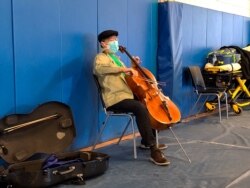 This photo provided by Berkshire Community College shows cellist Yo-Yo Ma performing at Berkshire Community College’s second dose Pfizer vaccination clinic in the Paterson Field House on March 13, 2021 in Pittsfield, Mass.