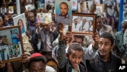 FILE - Members of Ethiopia's Jewish community hold up pictures of their relatives in Israel, during a solidarity event at a synagogue in Addis Ababa, Ethiopia, Feb. 28, 2018.
