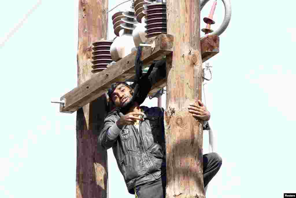 A Pakistani migrant threatens to hang himself from a utility pole during a demonstration inside the Moria registration center on the Greek island of Lesbos.