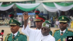 FILE - Nigeria's new President Bola Ahmed Tinubu, inspects honor guards after taking an oath of office at a ceremony in Abuja, Nigeria, May 29, 2023.