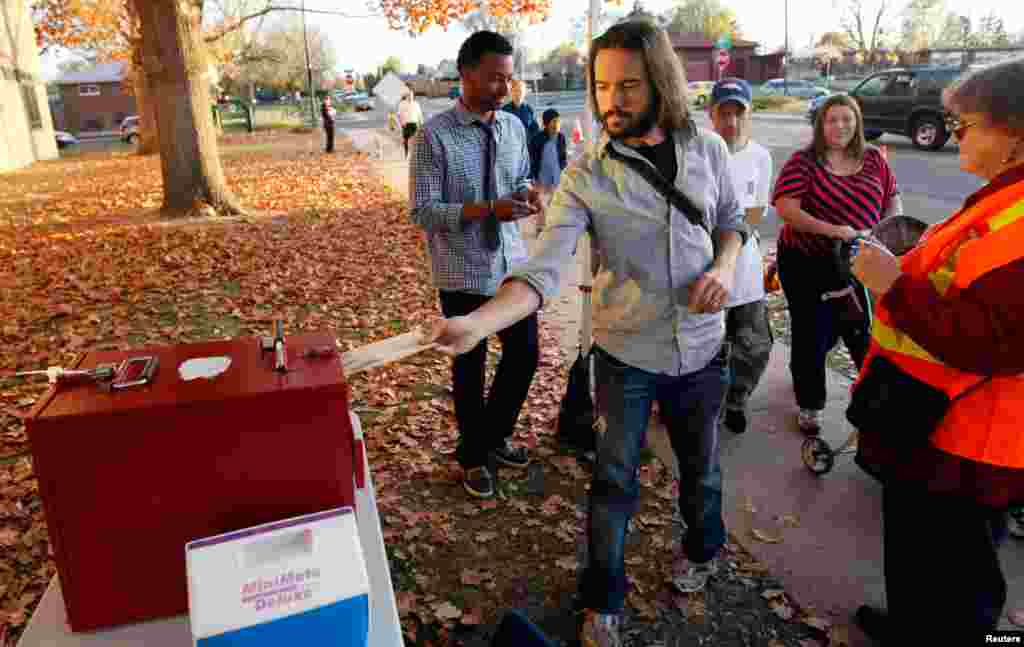 An Obama supporter casts his ballot early at an outdoor ballot box in Denver, Colorado October 30, 2012.