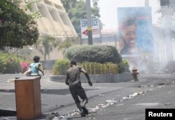 Gente huye mientras la policía usa gas lacrimógeno para dispersar disturbios en una calle de Puerto Príncipe, Haití, el 8 de julio de 2018. REUTERS / Andres Martinez Casares -