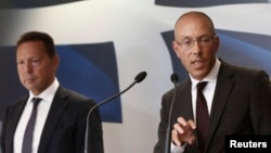 European Central Bank (ECB) executive board member Joerg Asmussen (R) addresses reporters next to Greece's Finance Minister Yannis Stournaras during a news conference in Athens, Aug. 21, 2013. 