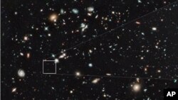 The farthest and one of the very earliest galaxies ever seen in the universe appears as a faint red blob in this ultra-deep–field exposure taken with NASA's Hubble Space Telescope