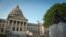 FILE - People stand next to the Confederate Mothers statue (R) outside the Mississippi State Capitol building during the state legislature's historic vote to change the Mississippi flag in Jackson, Mississippi on June 28, 2020.