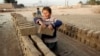 FILE - Children work at a brick-making factory in Jalalabad, Dec. 17, 2013. 