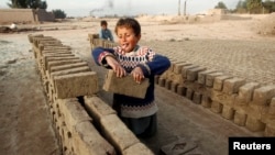 FILE - Children work at a brick-making factory in Jalalabad, Dec. 17, 2013. 