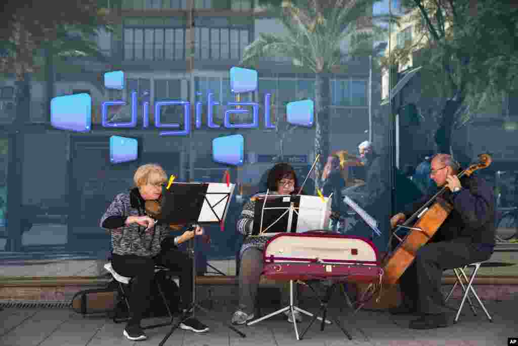 از مجموعه عکس های روزانه اسوشیتدپرس از زندگی در اسرائیل. چند نوازنده در کنار خیابان آثار موسیقی کلاسیک را در کنار بانکی در تل آویو اجرا می کنند.&nbsp;