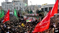 Dalam foto yang dirilis oleh Kantor Berita Mahasiswa Iran (ISNA), tampak bendera Iran menyelubungi peti jenazah Jenderal Qassem Soleimani dan rekan-rekannya dalam upacara pemakaman di Kota Ahvaz, Iran, 5 Januari 2020. Soleiman terbunuh dalam serangan udara oleh AS di Irak.