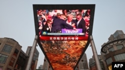 A news program about the assassination attempt on former U.S. President Donald Trump is seen on a giant screen at a shopping mall in Beijing July 14, 2024.