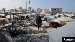 Palestinian man Hamada Abu Sleyma, whose wife, all six children and two grandchildren were killed in an Israeli strike that destroyed his house, walks on rubble, in Rafah in the southern Gaza Strip, Jan. 1, 2024.