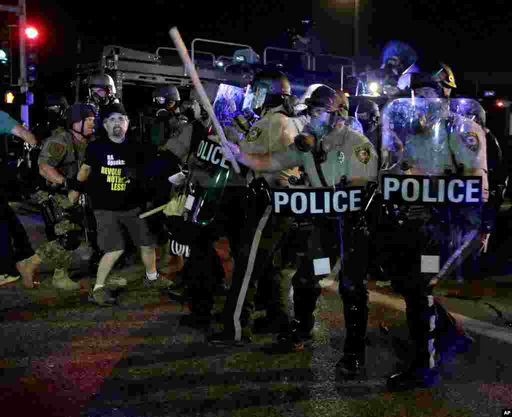 A man is detained after a standoff with police Monday, Aug. 18, 2014, during a protest for Michael Brown. (AP Photo/Charlie Riedel)