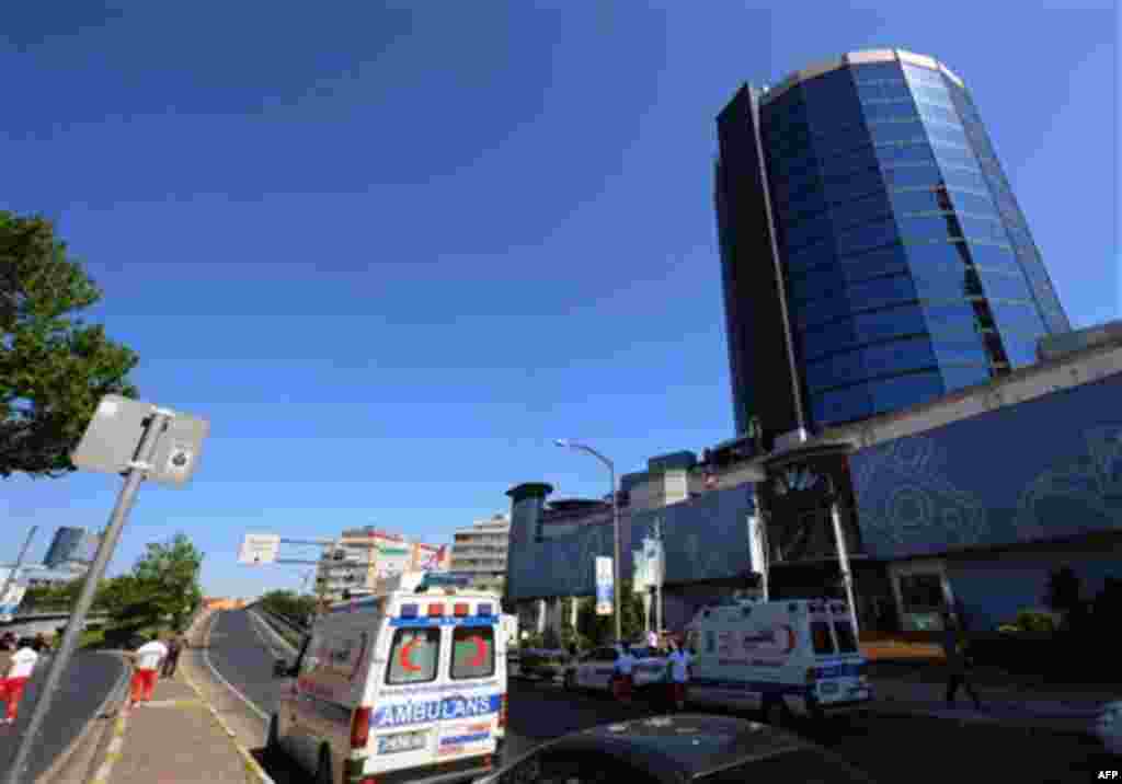 Ambulances wait as security members, medics and forensics work at the scene after a bomb exploded at a bus stop during rush hour in Istanbul, Turkey, Thursday, May 26, 2011. A bomb placed on a bicycle near a bus stop exploded during morning rush hour in