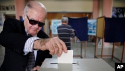 A man votes in the presidential election in southern port city of Limassol, Cyprus, February 24, 2013. 