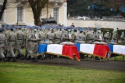 FILE - Servicemen stand by the coffins of three French soldiers who were killed in Mali serving in the country's Barkhane force, during a tribute ceremony at Thierville-sur-Meuse, France, Jan. 5, 2021.