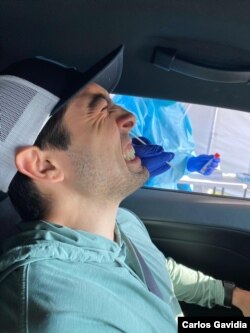 Casen Gavidia winces as he takes his coronavirus test at the drive-thru site.