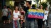 ARCHIVO - Un migrante venezolano porta un cartel en apoyo a Juan Guaidó en Montevideo, Uruguay, el 7 de febrero de 2019.