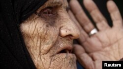 Khatla Ali Abdullah, 90, who recently fled her house in al-Mamoun district speaks with a Reuters journalist as she sits at her tent in Hammam al Alil camp, while Iraqi forces battle with Islamic State militants, in western Mosul, Iraq March 1, 2017. 