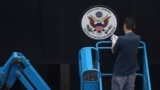 A worker removes the sign at the entrance to the US consulate in Chengdu