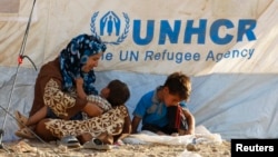 Iroqning Arbil shahri tevaragidagi suriyalik qochqinlaSyrian refugees rest at a new refugee camp on the outskirts of the city of Arbil, in Iraq's Kurdistan region, August 20, 2013. The government of Iraqi Kurdistan has set an entry quota of 3,000 refugees a day to cope with an influx of Kurds fleeing the ci