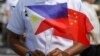 Seorang anggota Gara Pantai Filipina memegang bendera saat kunjungan persahabatan kapal Angkatan Laut China, Qi Jiguang, di pelabuhan Manila, Filipina, 14 Juni 2023. (Foto: AP)