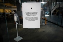 FILE - A closed notice is seen on an Apple store at the capital city's popular shopping mall following the COVID-19 outbreak, in Beijing, Feb. 10, 2020.