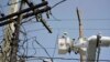 FILE - A brigade from the Puerto Rico Electric Power Authority repairs distribution lines damaged by Hurricane Maria in the Cantera community of San Juan, Puerto Rico, Oct. 19, 2017. The storm struck after the authority had filed for bankruptcy in July, put off maintenance and had finished dealing with outages from Hurricane Irma.