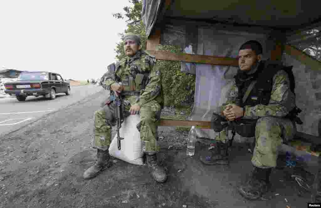 Soldiers from the Ukrainian self-defence battalion "Azov" sit at a checkpoint in Mariupol, Sept. 8, 2014. 